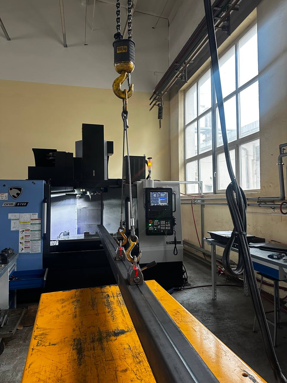 The shop floor: the DNM 6700 machining centre, an overhead crane and daylight from the window wall.